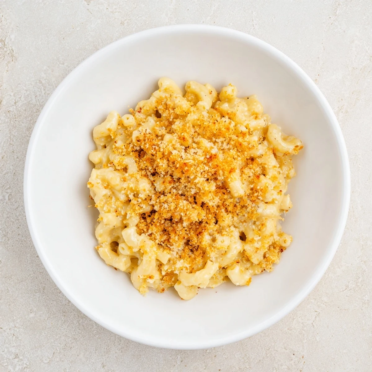 A close-up of a cheesy Classic Oven-Baked Macaroni and Cheese topped with crunchy breadcrumbs, ready to eat.