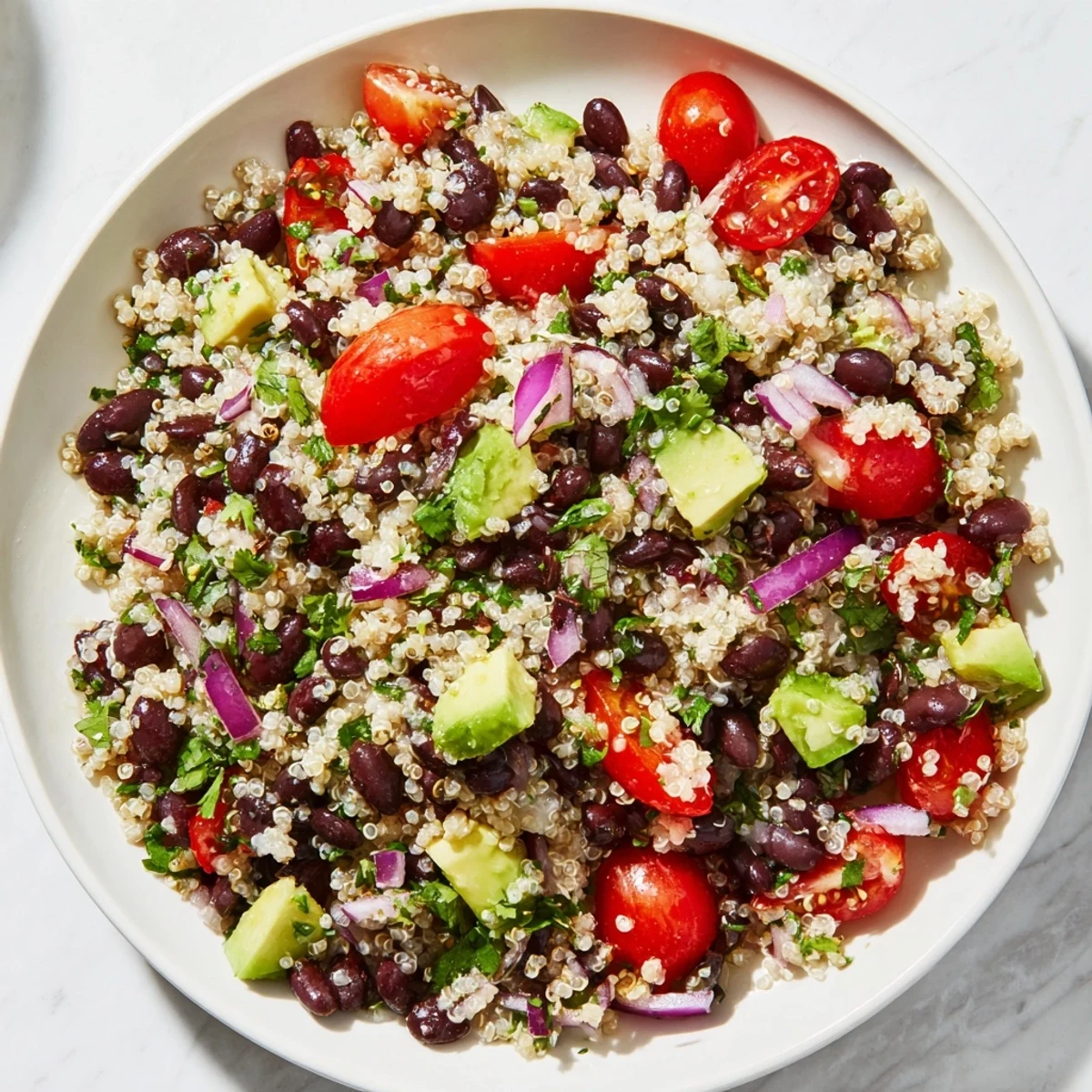 Fluffy quinoa and black bean salad with vibrant veggies and zesty lime dressing is refreshing.