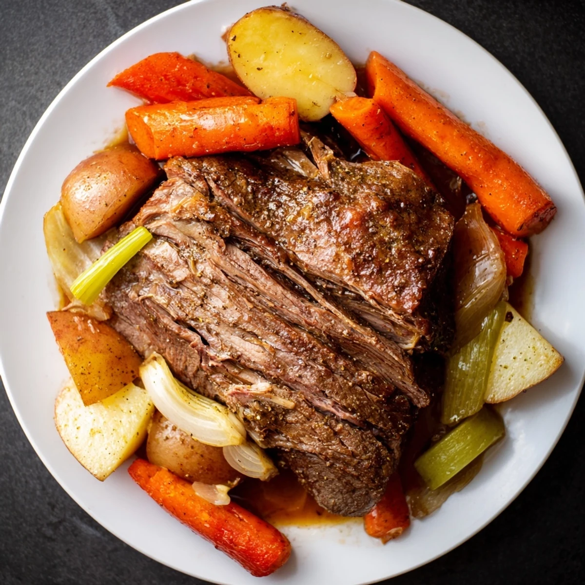 Fork-tender Slow-Roasted Beef Pot Roast in rich broth with carrots, potatoes, and other vegetables.