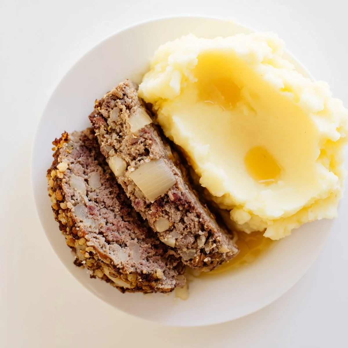 Golden-brown Scottish haggis alongside yellow neeps and fluffy mashed tatties, ready to eat.