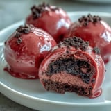 A close-up reveals the smooth texture of these Oreo Truffle Balls with Pink Candy Coating on a plate. 