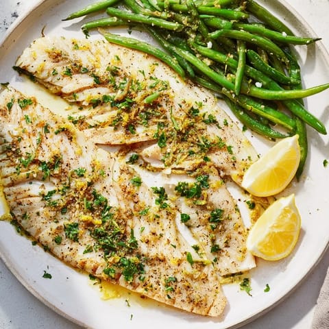 Tender, flaky lemon herb tilapia cooked with beautifully roasted green beans, perfect for a weeknight dinner.