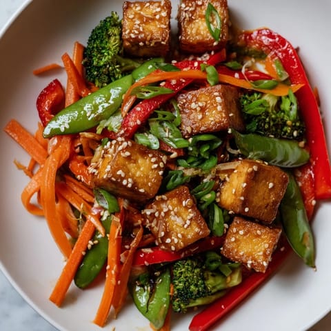 Steaming bowl of Sesame Ginger Tofu Stir-Fry: a quick, delicious vegetarian dinner with a rich aroma.