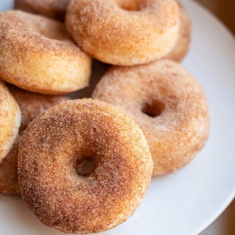A close-up shot of freshly glazed cinnamon-sugar baked donuts, ready to be devoured with coffee.