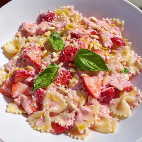 Creamy pink Strawberry Sour Cream Pasta beautifully coated, ready for serving on a plate.