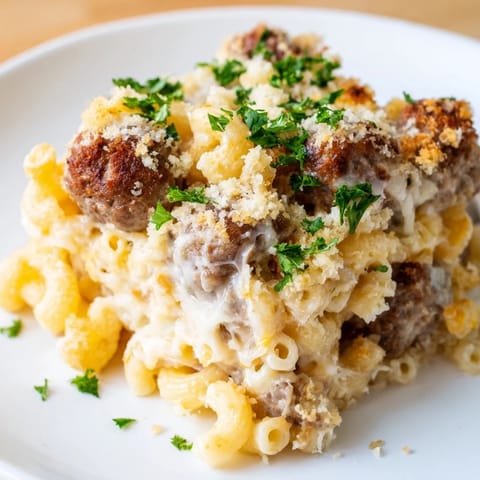 A close-up of a sizzling Mac & Cheese Meatball Bake, showcasing the delicious, cheesy pasta and juicy meatballs.