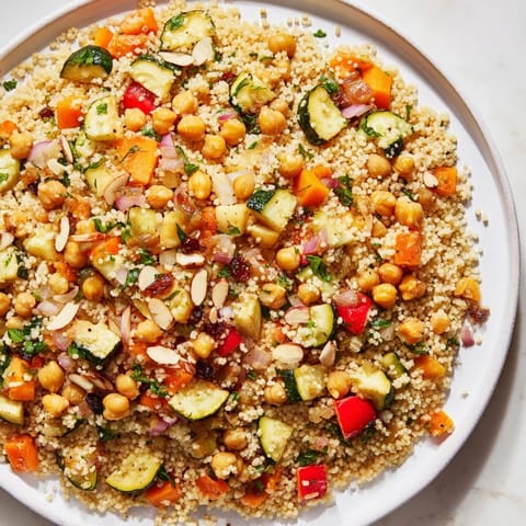 Bright, fluffy Moroccan couscous salad features golden roasted veggies, fresh herbs, and a tangy dressing.