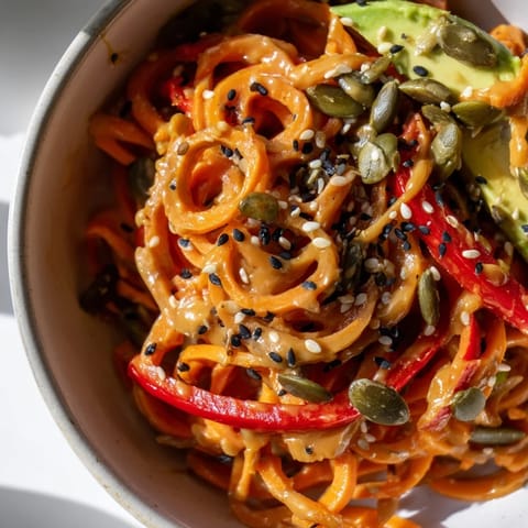 In this healthy Carrot Noodle Skincare Bowl, spiralized carrots mingle with spinach, red bell pepper, and a rich sesame-lime sauce.