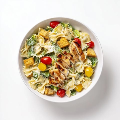 Sliced grilled chicken and al dente pasta mingle with fresh romaine and cherry tomatoes in this hearty Caesar Pasta Chicken Bowl.