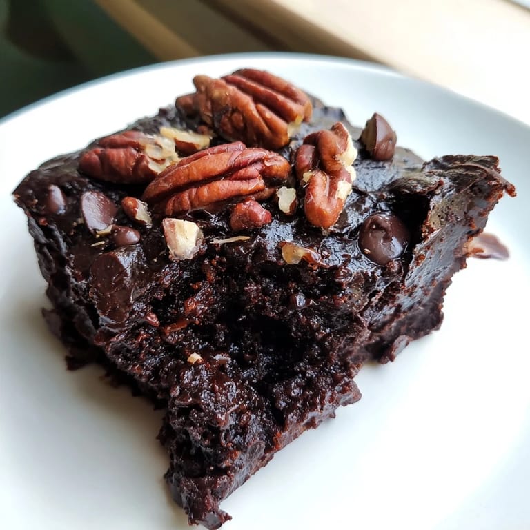 Fudgy, gluten-free black bean brownies topped with chocolate chips cooling on a rack.