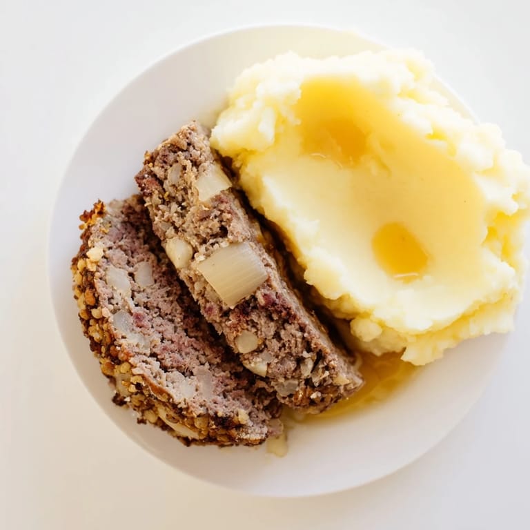 Golden-brown Scottish haggis alongside yellow neeps and fluffy mashed tatties, ready to eat.