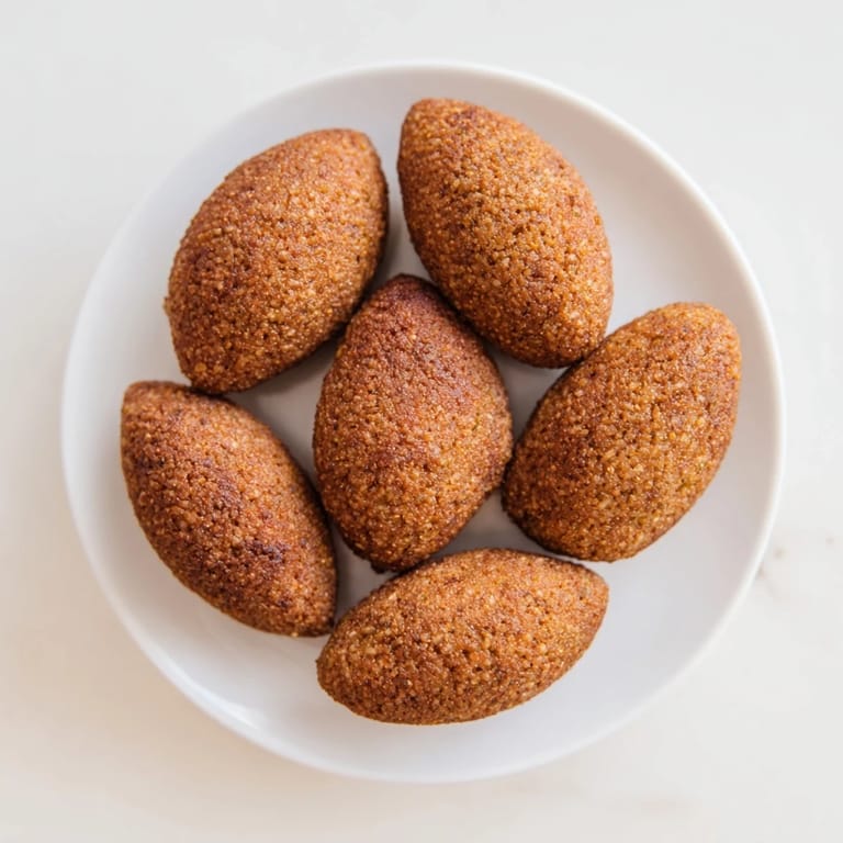 Served with fresh parsley, this plate of Lebanese Kibbeh is ready for dipping in creamy sauce.