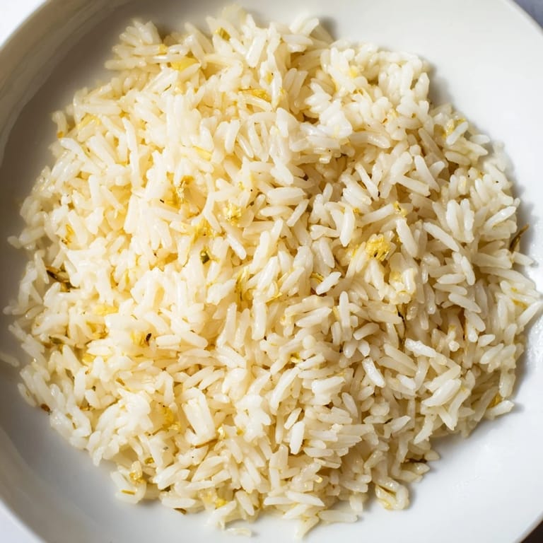 Golden garlic butter rice with tender grilled chicken slices and fresh parsley, served as a comforting, flavorful main dish.  