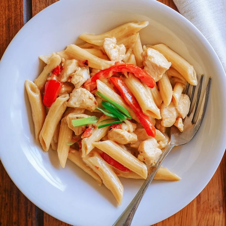 Steaming bowl of Sweet Chili Chicken Pasta, a creamy fusion dish with golden chicken and pasta tossed in a sweet and spicy sauce.