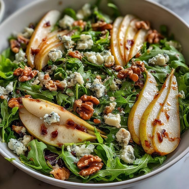 Vibrant Arugula and Pear Bowl with glossy pears, crumbled cheese, and honey-Dijon vinaigrette on a rustic plate.