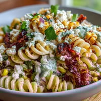 Vibrant Elote Pasta Salad with Cotija, Chili, and Lime, bursting with charred corn and zesty dressing.