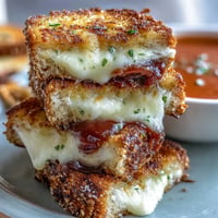 Golden mini grilled cheese dippers await dipping in steaming, creamy tomato soup.
